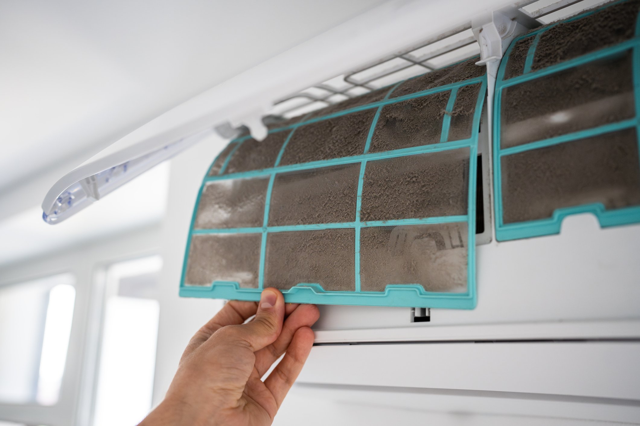 A blocked filter being removed from a split system air conditioner